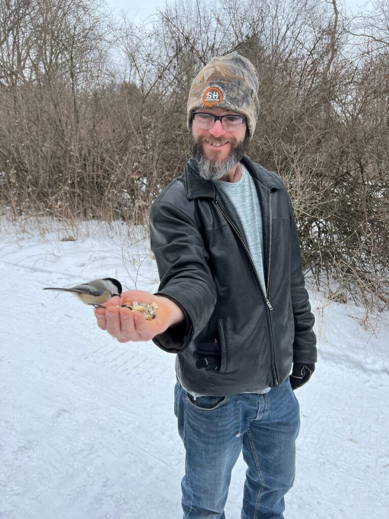 Jacob feeding black-capped chickadee at Mendon Ponds NY