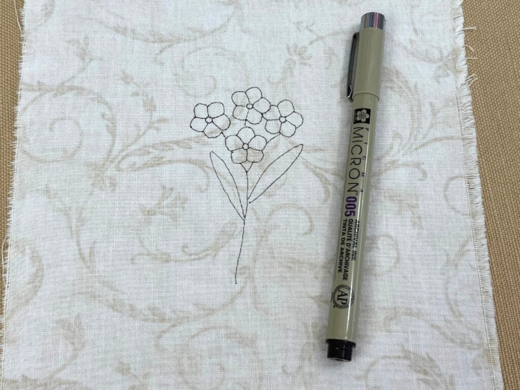 Micron pen used for tracing Firget Me Not flowers for hand embroidery.