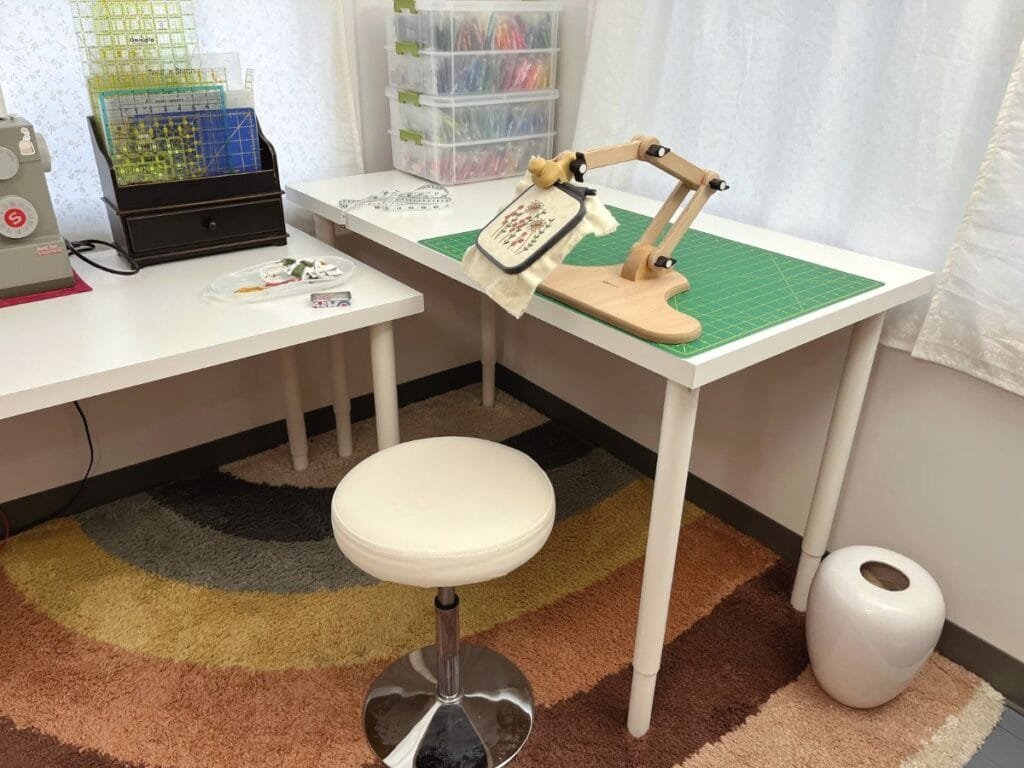Studio space with two tables, a rainbow rug and my new Nurge embroidery stand.