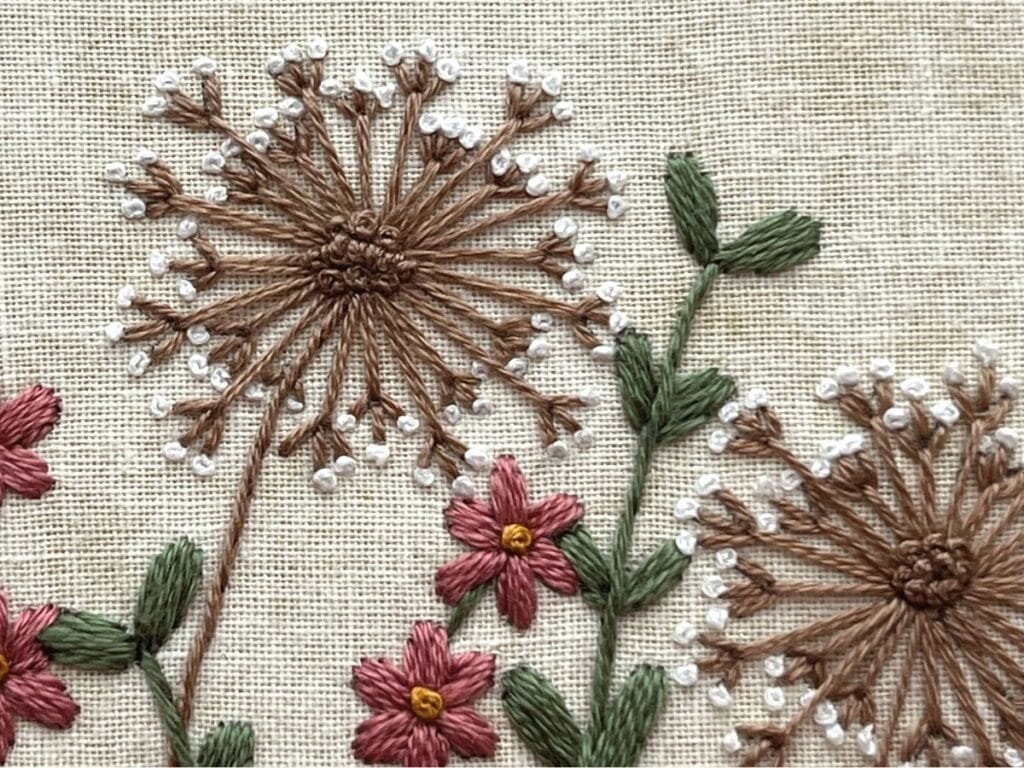 Close up of fly stitch, french knots, satin stitch and stem stitch.