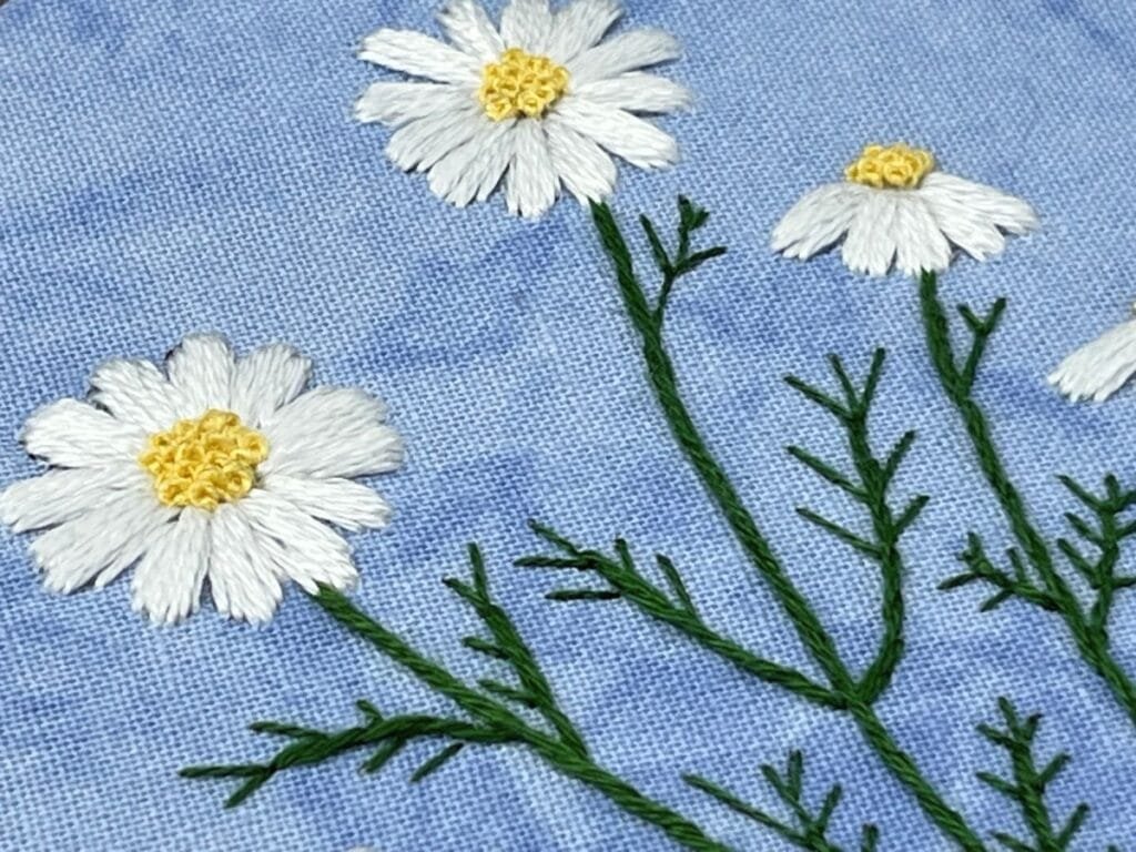 Close up of wild daisy hand embroidery.
