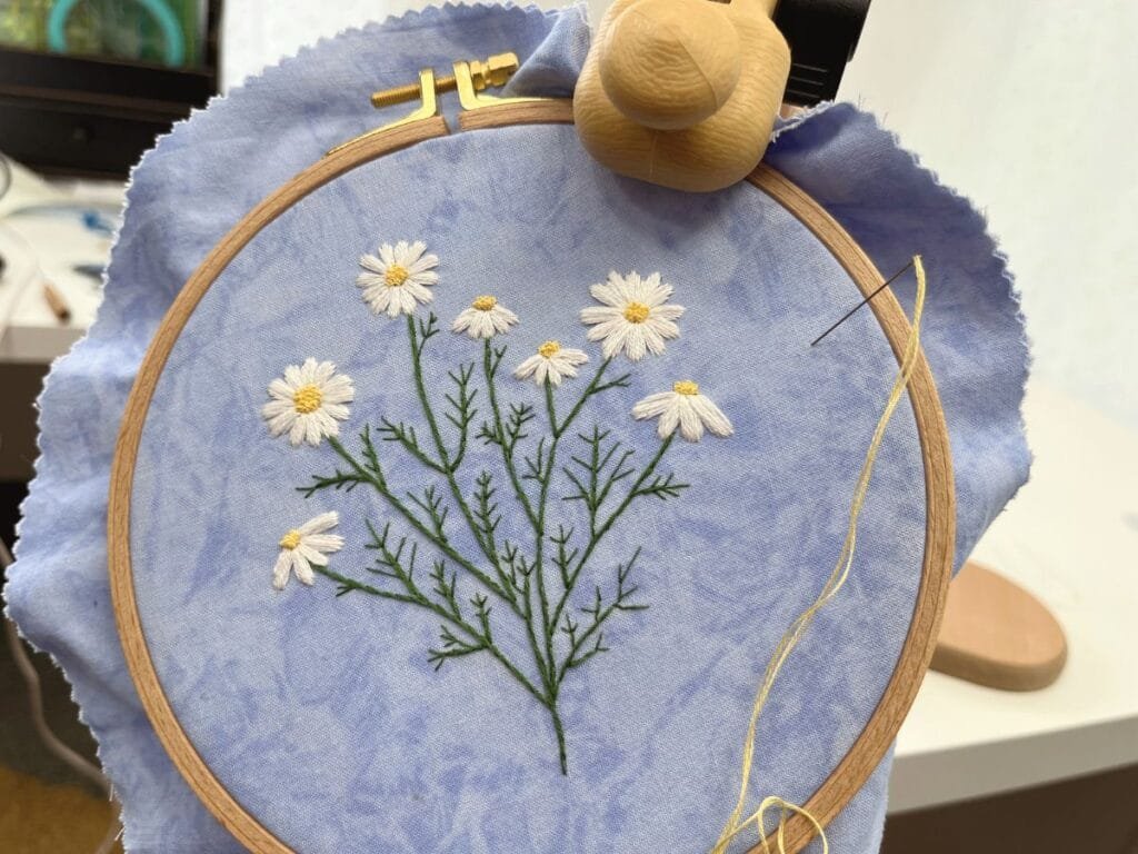 Wild daisy hand embroidery in a nurge stand and nurge hoop with a Tulip needle.